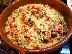 Печено заешко месо с ориз, чушки, чесън, лук, маслини и магданоз в глинен гювеч на фурна - снимка на рецептата